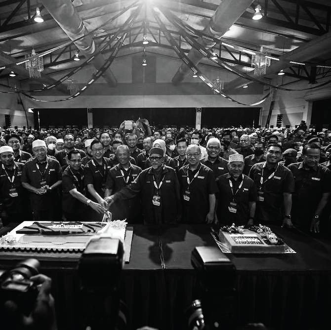 Leaders before a packed hall, black and white