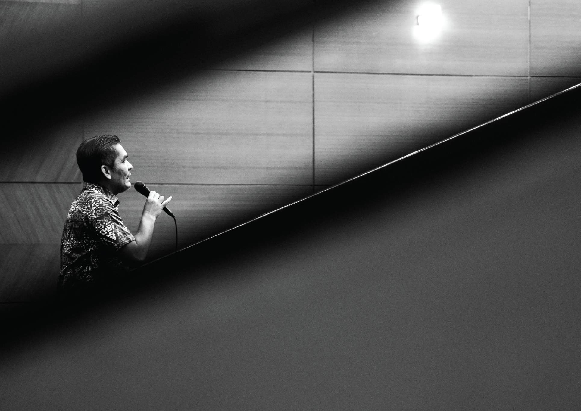 Speaker with microphone on a staircase, black and white